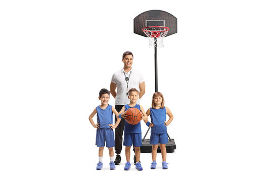 Basketball coach with children in front of a hoop on stand