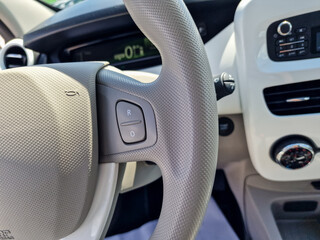 Closeup view of a sleek, modern car steering wheel showcasing various controls for gear shifting...