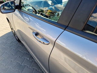 The shiny silver car door, complemented by a sleek chrome handle, truly embodies the essence of...