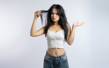 Disappointed woman with unkempt hair expressing frustration in casual clothes against white backdrop