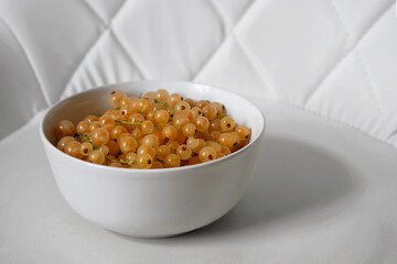 Fresh Yellow Currants in a White Bowl on White Background