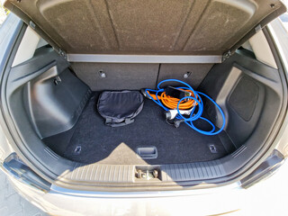 A generously spacious car trunk equipped with essential electric charging cables and a convenient...