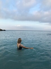 Woman in a swimsuit floating peacefully near the shore.
