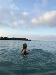 Young woman swimming in the crystal-clear Mediterranean waters.
