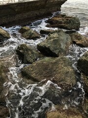 Peaceful view of the coast with rocks and hills.
