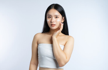Applying Facial Moisturizer: Beautiful woman applying skincare product for hydrated radiant skin