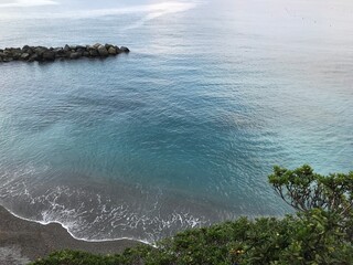 Picturesque rocky shoreline with waves gently breaking.
