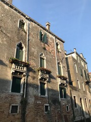 Row of pastel buildings beside a Venetian canal.

