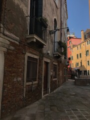 Venetian houses with laundry hanging above a canal.
