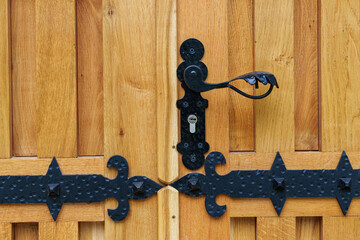 close up view of old wooden door made of planks and metal decorative elements as background