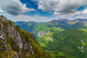 Fototapeta premium Dramatic scenery with clouds and lush green flora in the Carpathians Mountains in spring