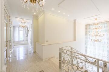 Elegant interior featuring marble floors, white walls, decorative railings, and crystal...