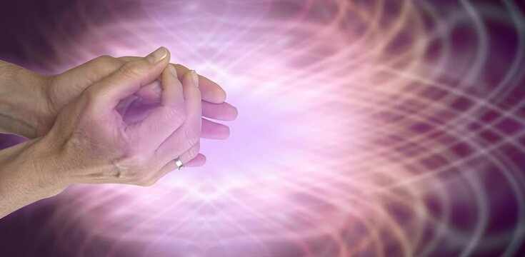 Male healer working with a pink energy field sensing with his hands