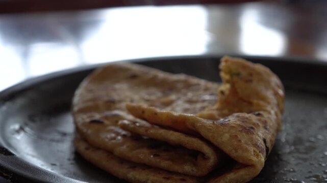 aloo paratha closeup shot on plate with hand