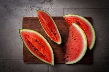 Fresh organic watermelon with a slices on gray background, top view