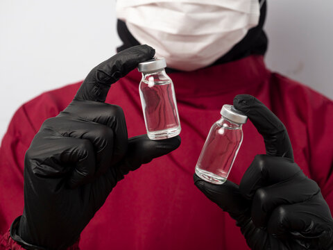 Close-up of a doctor, nurse, and female scientist holding a blank vial on an isolated background. Blank medical vial mockup concept for pharmaceutical, vitamin, and research companies.
