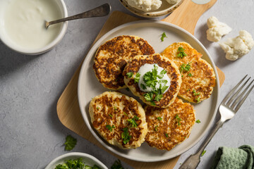Vegetarian cauliflower pancakes, fritters served with sour cream 