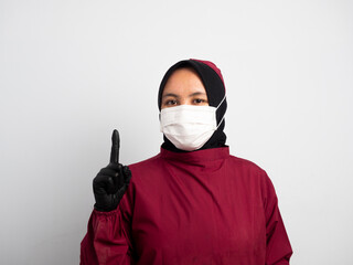Close up of female Doctor pointing with finger on virtual touchscreen in medical futuristic interface. Doctor, young Asian Muslim nurse gives index finger as a gesture of pointing at something.
