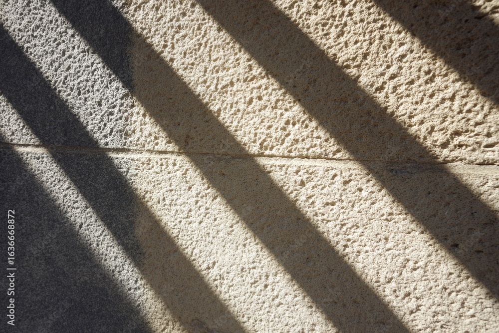Poster diagonal shadows create intriguing patterns on textured surface,
