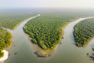 Aerial view of rivers snaking through the dense, verdant mangroves, creating a tapestry of green and blue, Sundarban, Khulna Division, Bangladesh.