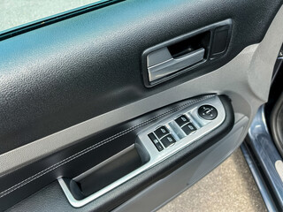 This is a detailed closeup image showcasing the car door control panel, prominently featuring...