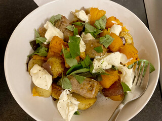 Fresh and colourful one pot sausage and squash bake with new potatoes, basil and creme fraiche in a...