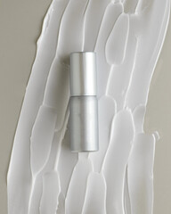 Silver Skincare Bottle on Cream Texture Background &ndash; Grey and White Tones Beauty Concept