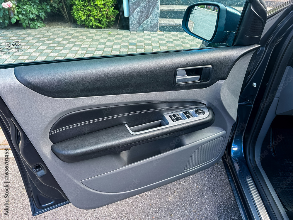 Poster this image features an interior closeup view of a modern car door panel showcasing various controls 
