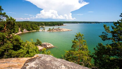 Obraz premium Scenic coastline with lush green forest and calm water