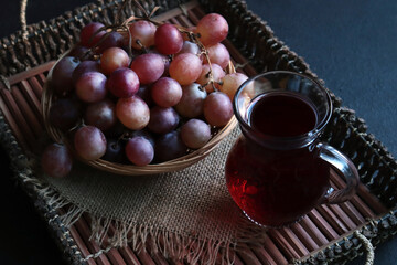 Traditional Turkish grape juice served on a wooden tray with a basket of fresh grapes
