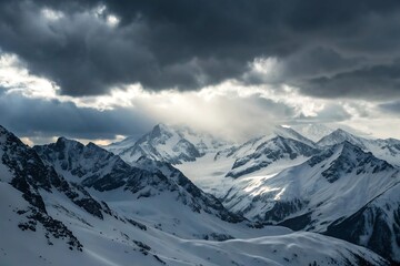 Obraz premium Dramatic sunbeams pierce through stormy skies over majestic snow covered mountain peaks