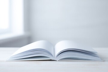 Fototapeta premium Open book rests on wooden table, showcasing blank pages in soft