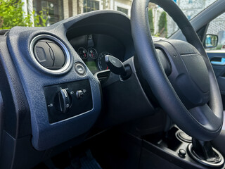 Detailed closeup view of the intricate dashboard controls and steering wheel of a contemporary...