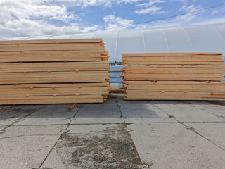 Sawn boards, timber against the background of an industrial hangar.