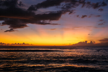Beautiful and exotic sunset at Kuta Beach, Bali, Indonesia, captured from the shoreline. The golden sky reflects on the waves, attracting many tourists to witness this must-see view in Bali.