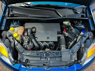 This closeup photo of a blue car engine showcases its intricate components, offering insights into...