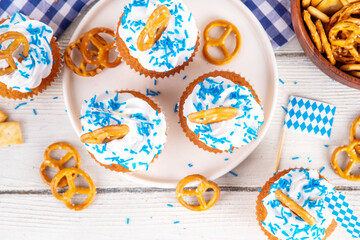 Oktoberfest cupcakes with salted pretzel, whipped cream on top and colorful sugar sprinkles, on...
