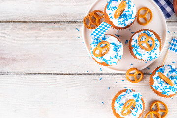 Oktoberfest cupcakes with salted pretzel, whipped cream on top and colorful sugar sprinkles, on...