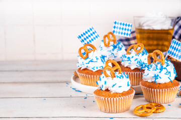 Oktoberfest cupcakes with salted pretzel, whipped cream on top and colorful sugar sprinkles, on...