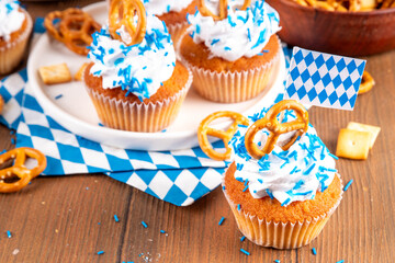 Oktoberfest cupcakes with salted pretzel, whipped cream on top and colorful sugar sprinkles, on...