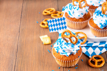 Oktoberfest cupcakes with salted pretzel, whipped cream on top and colorful sugar sprinkles, on...