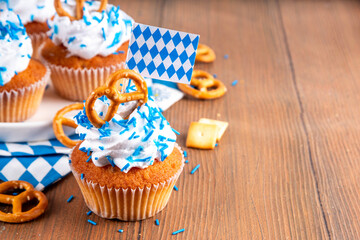 Oktoberfest cupcakes with salted pretzel, whipped cream on top and colorful sugar sprinkles, on...