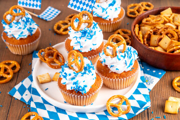 Oktoberfest cupcakes with salted pretzel, whipped cream on top and colorful sugar sprinkles, on...