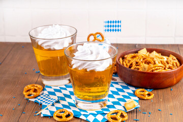 Oktoberfest dessert idea, two glasses with colorful beer styled golden jelly pudding with whipped...