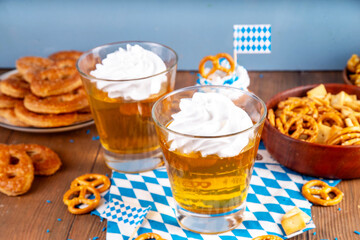 Oktoberfest dessert idea, two glasses with colorful beer styled golden jelly pudding with whipped...