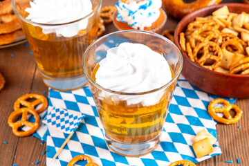 Oktoberfest dessert idea, two glasses with colorful beer styled golden jelly pudding with whipped...