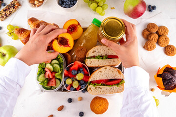 Preparation or ready made brunch box with sandwiches, salad, croissant, cookie and fruit for...