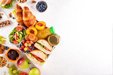 Preparation or ready made brunch box with sandwiches, salad, croissant, cookie and fruit for...