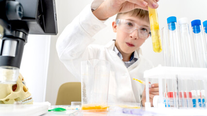 The boy conducts chemical experiments in the laboratory