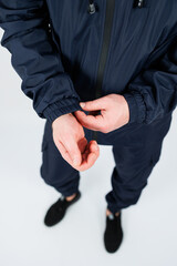 A CloseUp Shot of a Person Elegantly Adjusting Their Cuffs While Dressed in Trendy Navy Sportswear  Perfect for Promotions That Emphasize an Active and Dynamic Lifestyle for Everyone to See